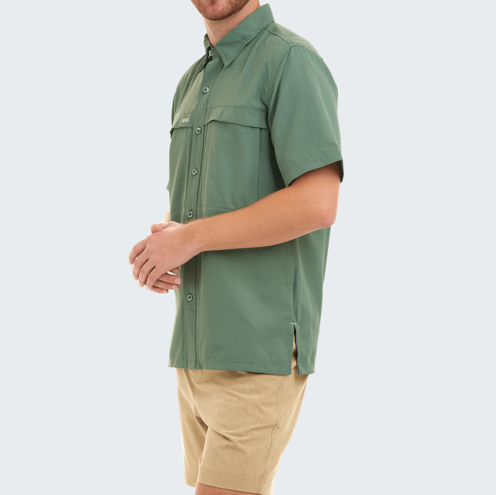 Person wearing a green shirt and beige shorts on a white background