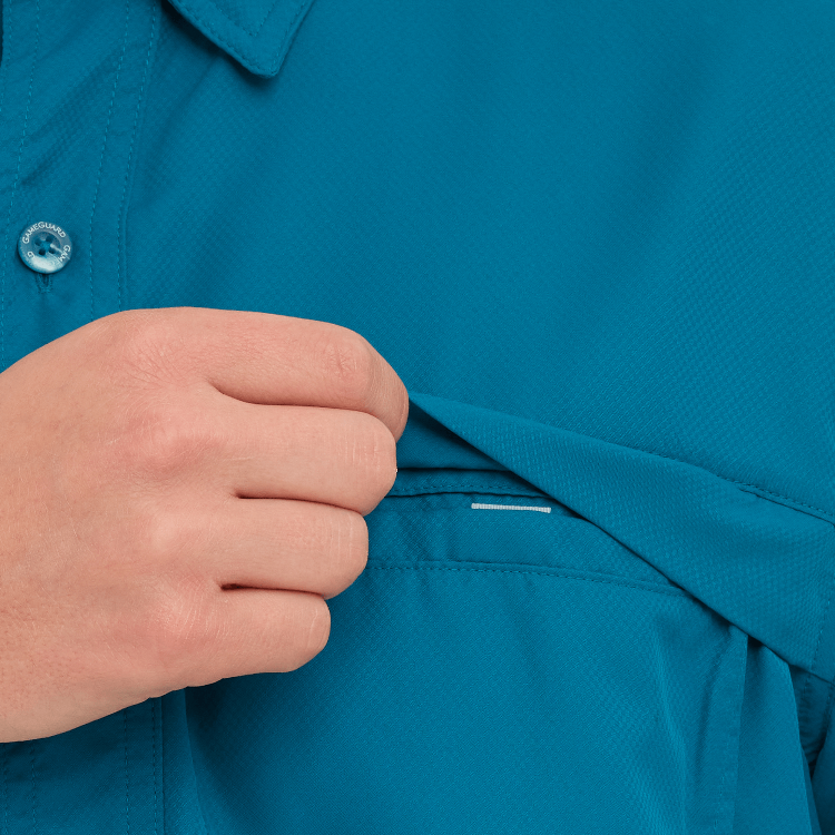 Close-up of a hand adjusting a blue shirt collar with a plain background