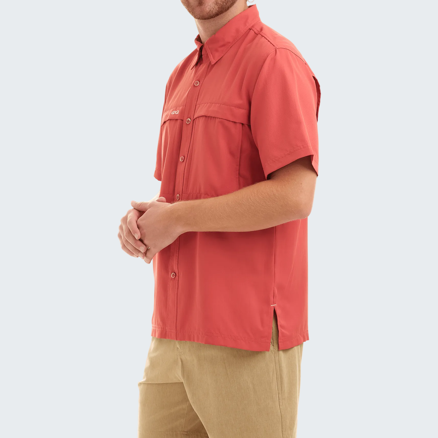 Man wearing a red shirt and beige pants on a white background