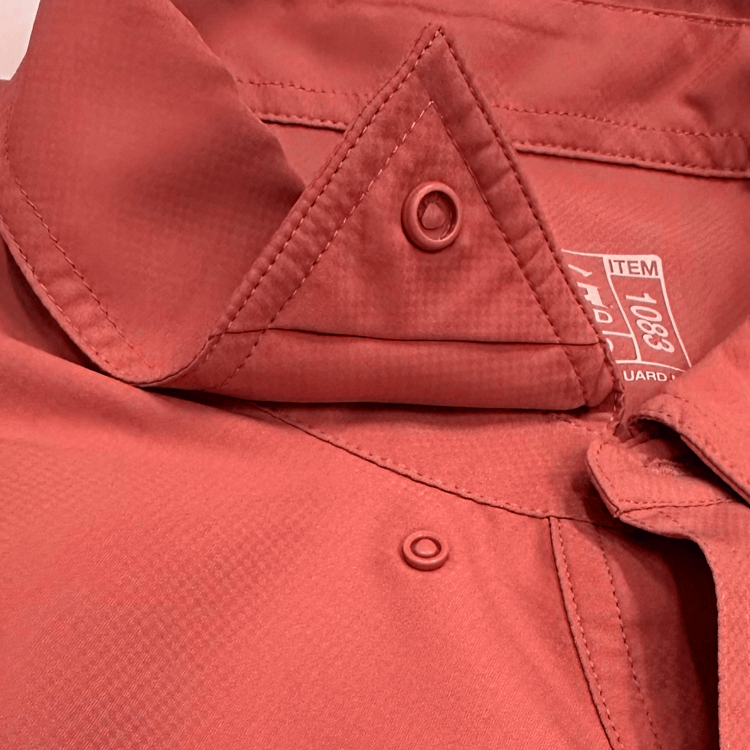 Close-up of a red jacket with a button and brand label.