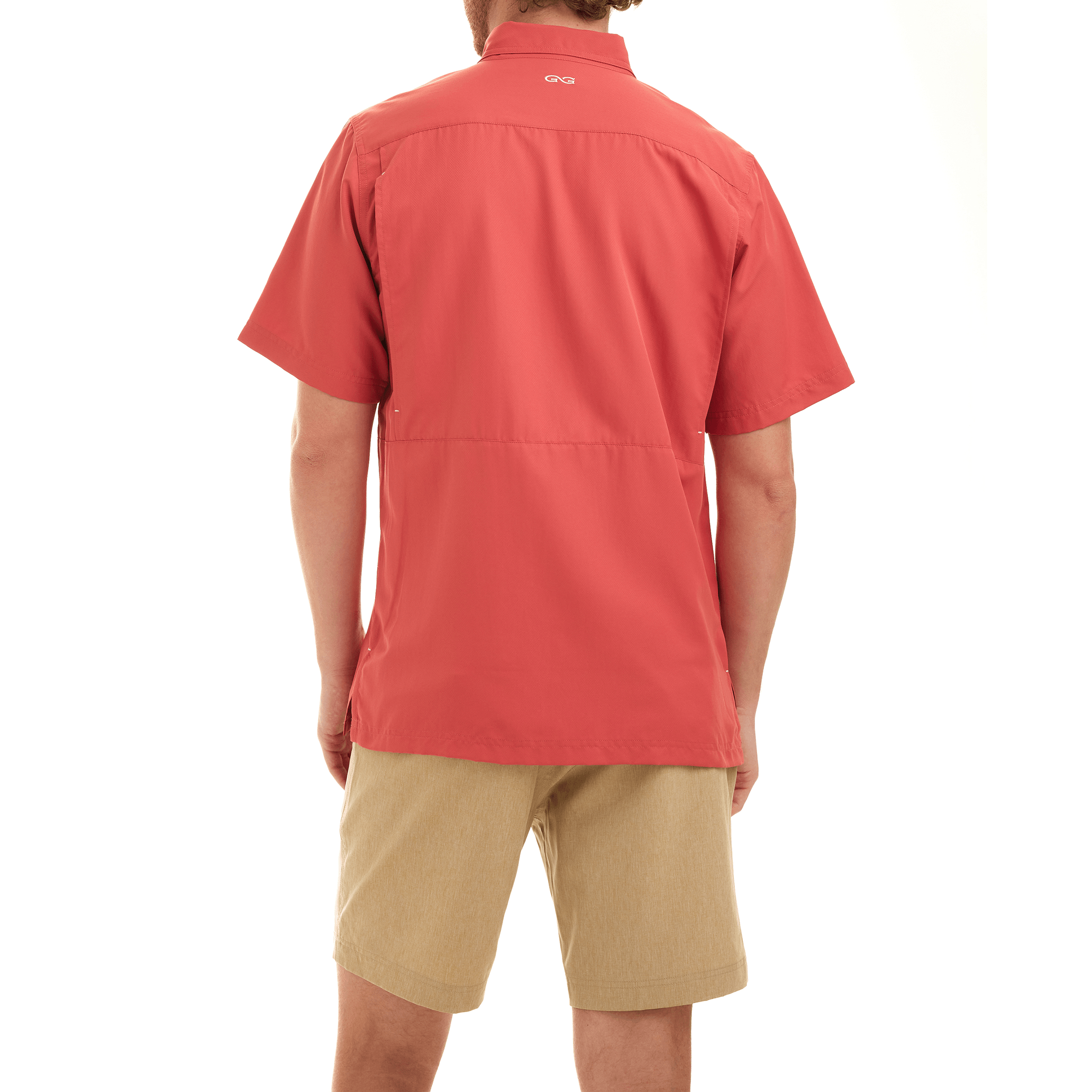 Person wearing a red shirt and beige shorts on a white background