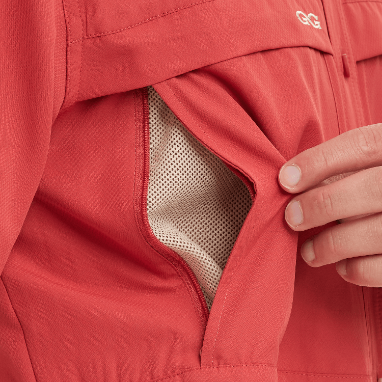 Close-up of a red jacket with a hand adjusting the hood, featuring a brand logo.