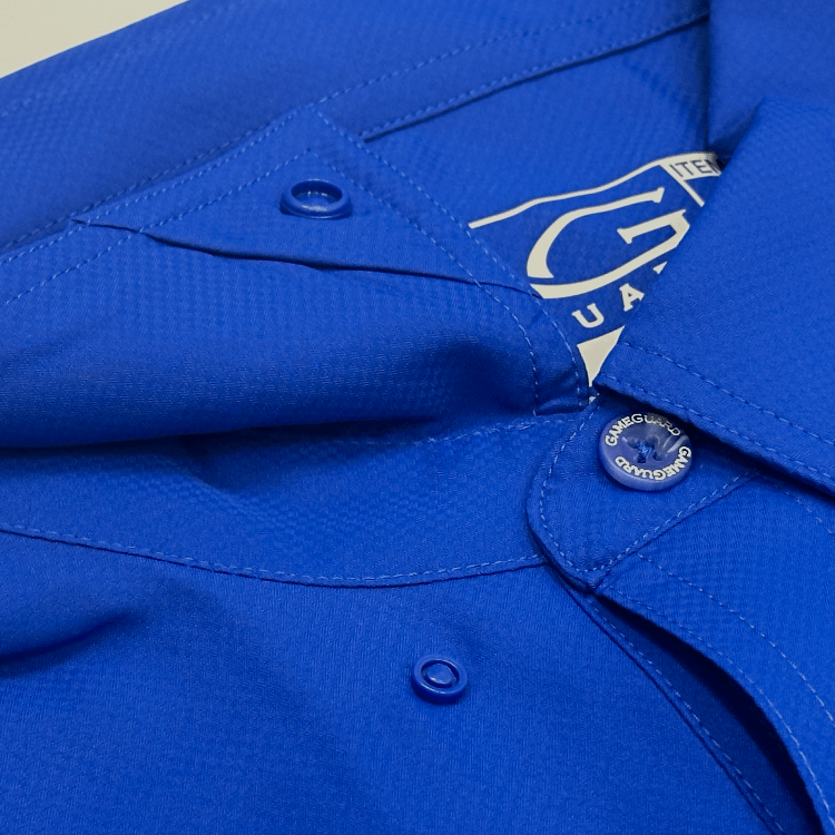 Close-up of a blue shirt with a brand label on a beige background
