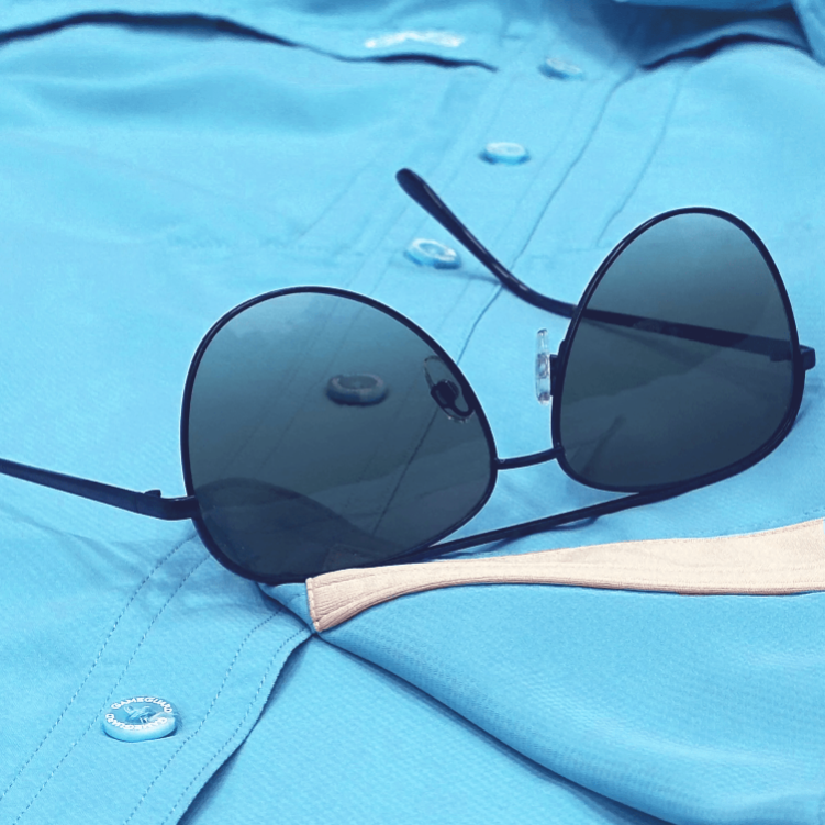 Black sunglasses on a light blue shirt