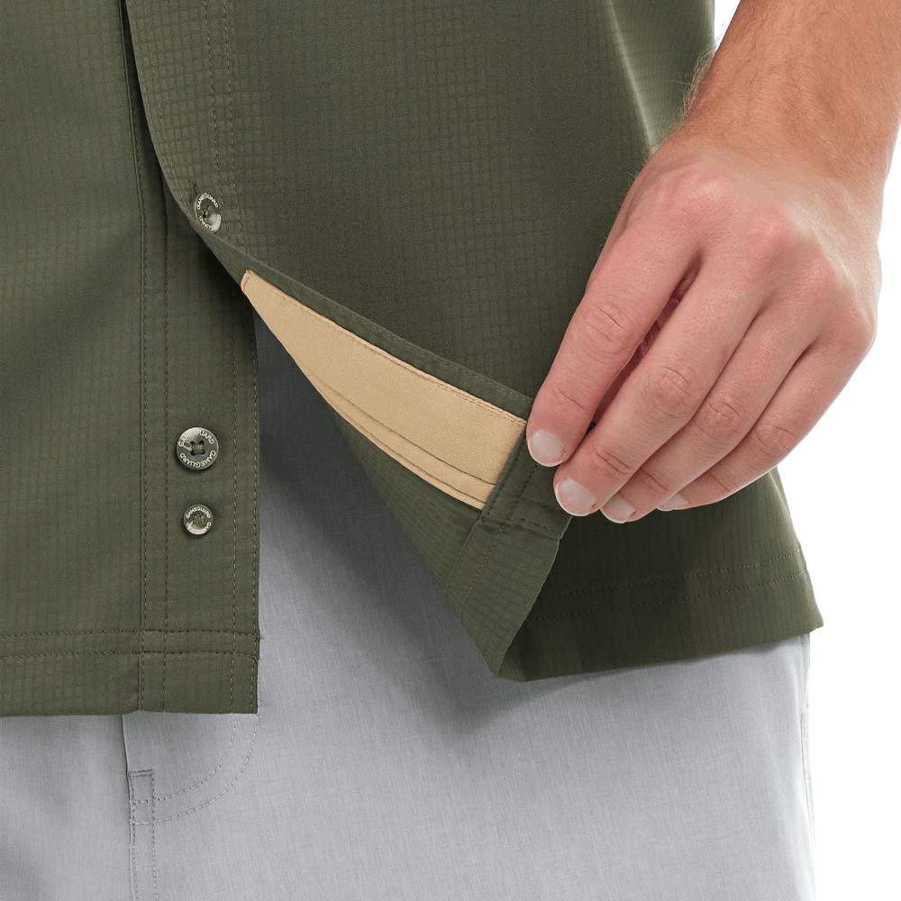 Close-up of a person adjusting the collar of a green jacket with a beige lining.