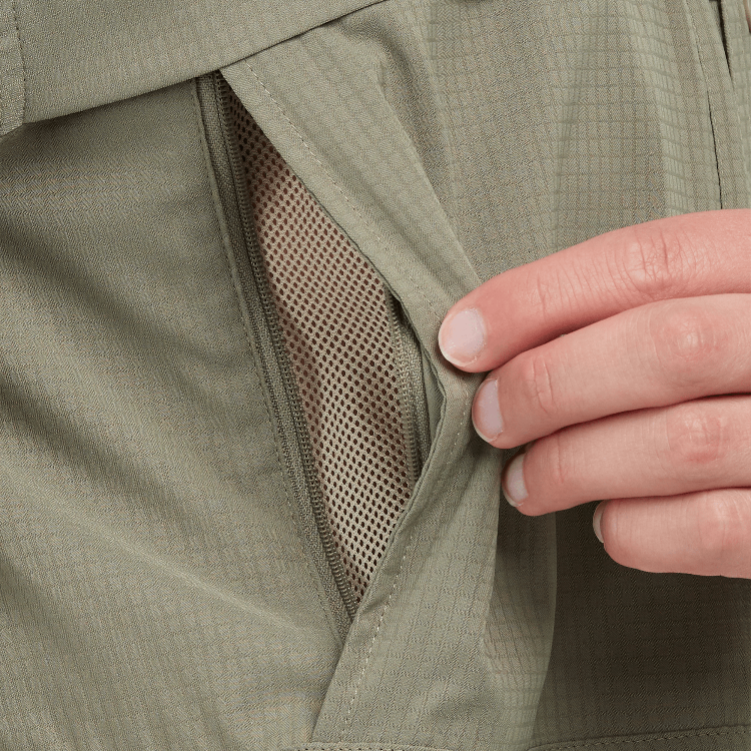 Close-up of a hand adjusting a green jacket with mesh lining.