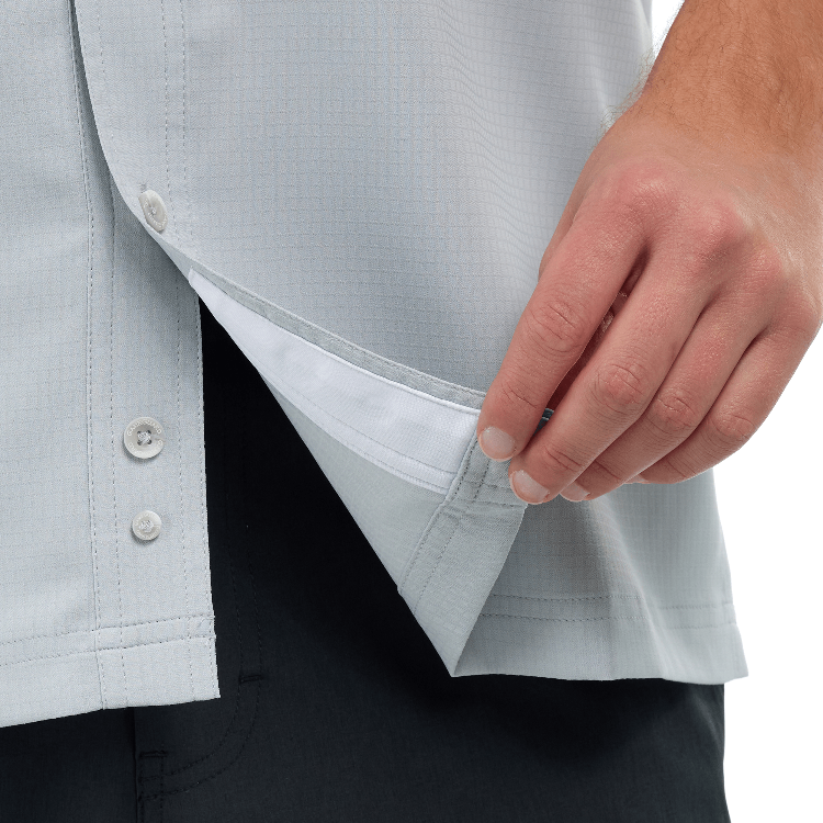 Close-up of a light gray shirt with a button being pressed, on a white background
