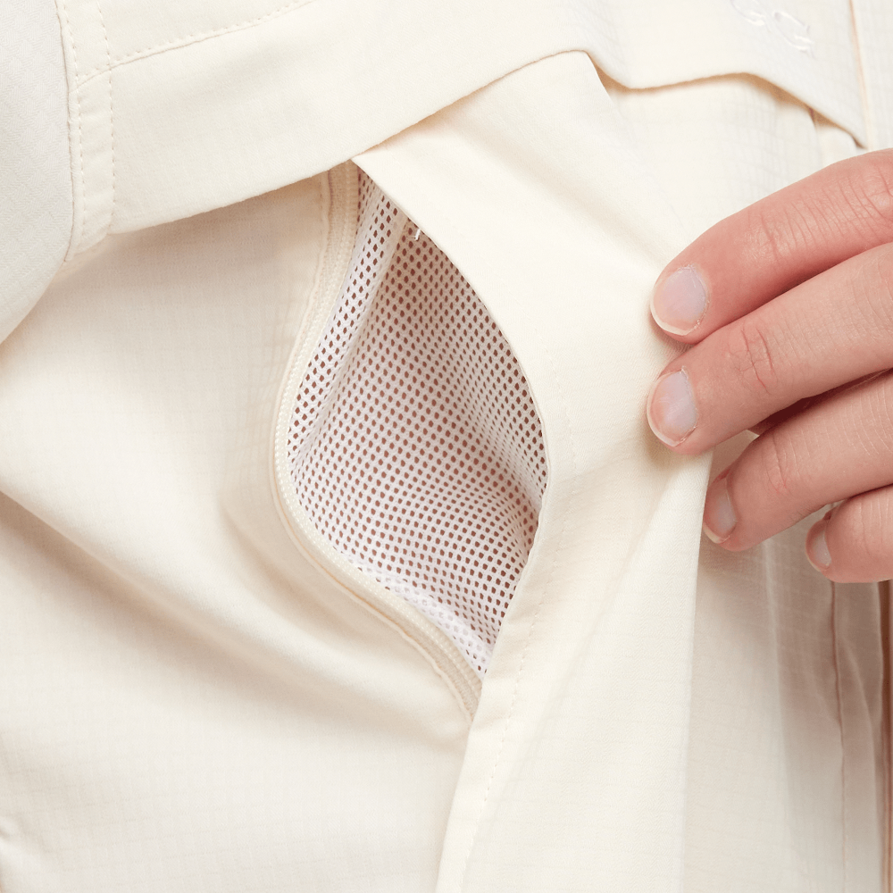 Close-up of a beige garment with a hand touching the fabric