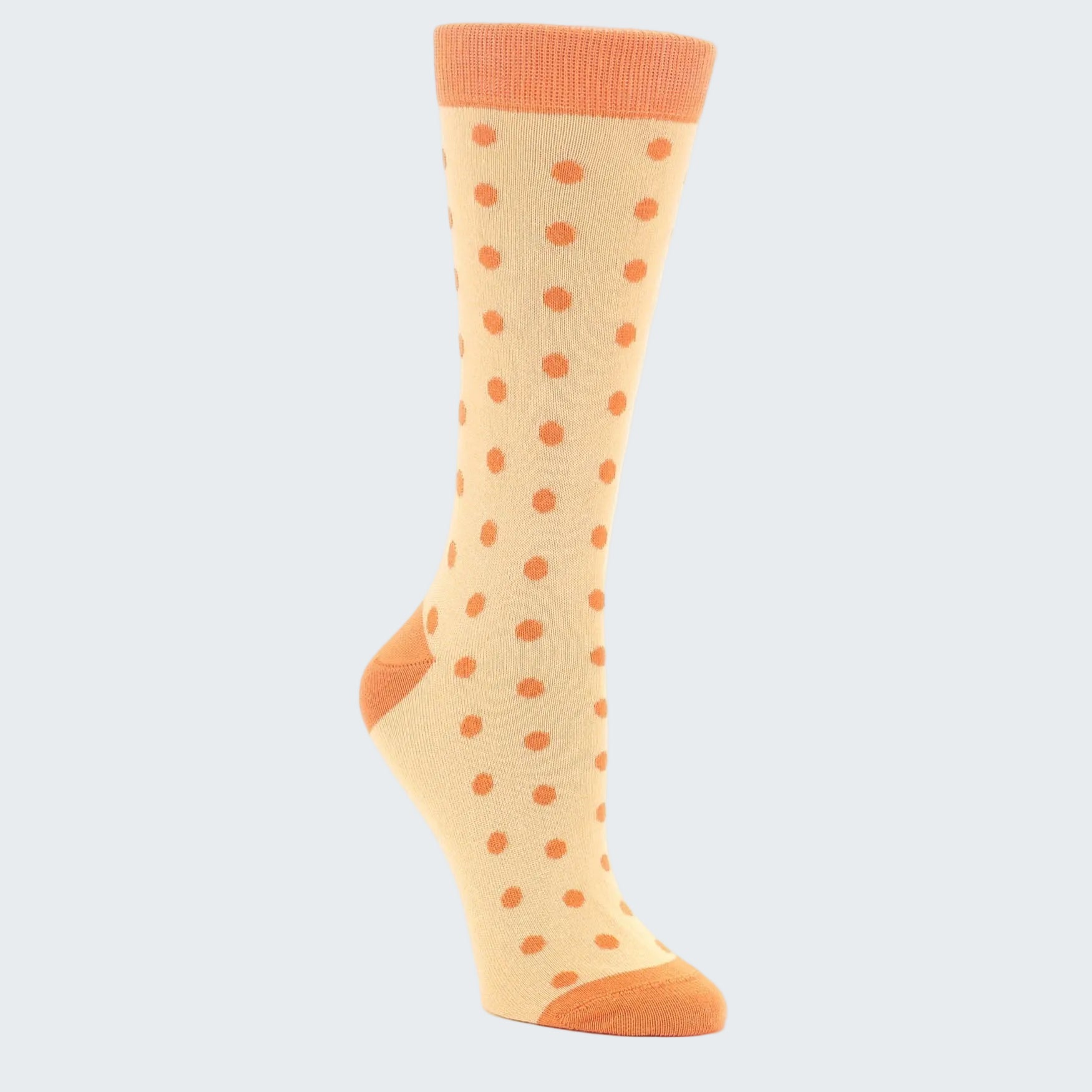 Beige sock with orange polka dots on a white background