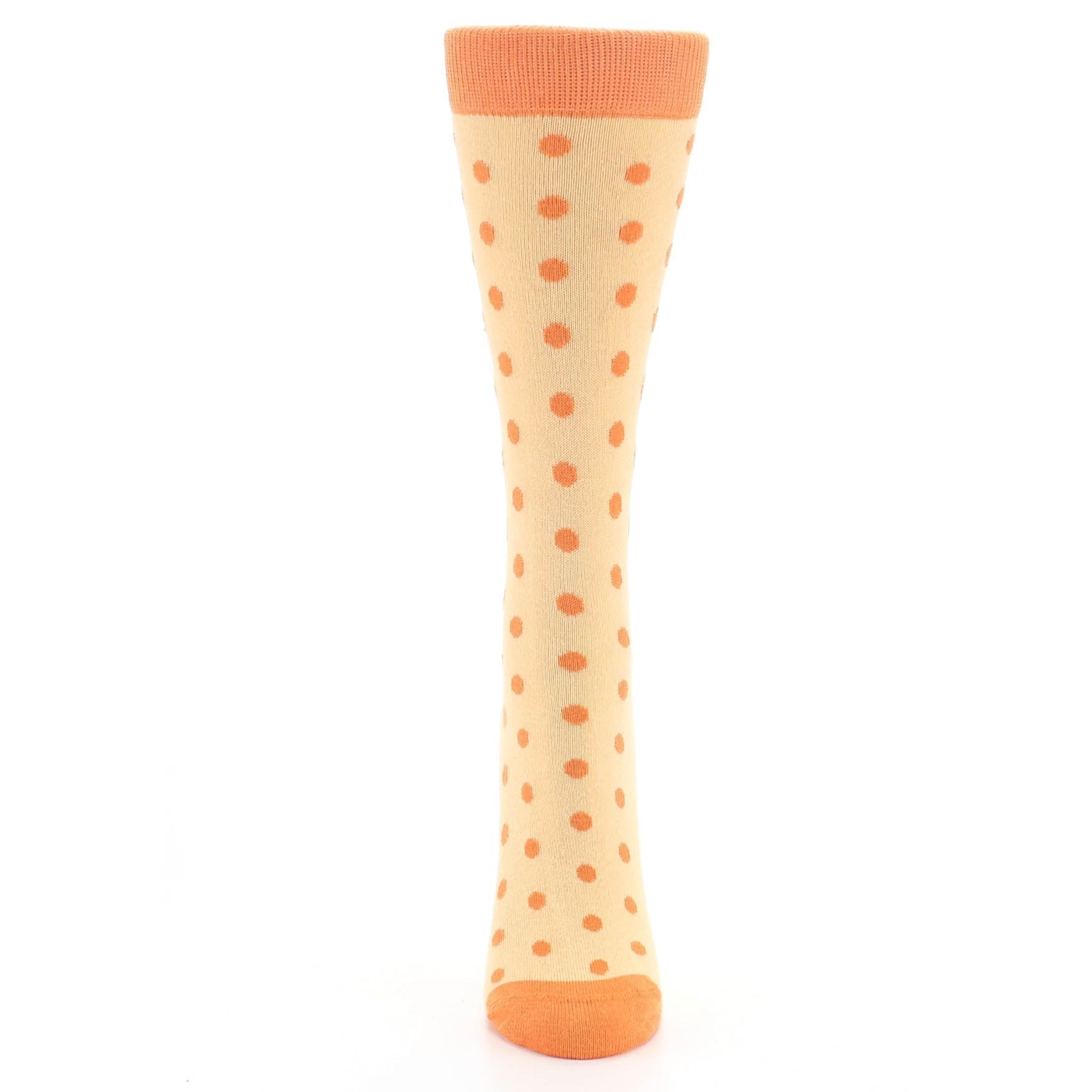 Beige knee-high sock with orange polka dots on a white background