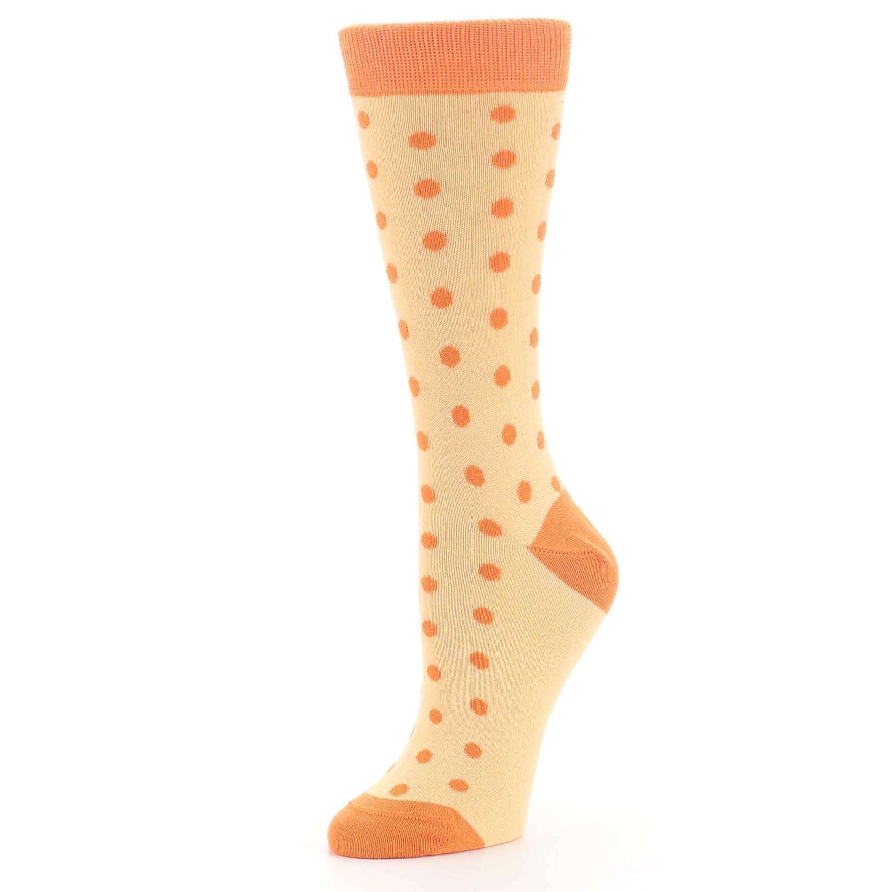 Beige sock with orange polka dots and cuffs on a white background