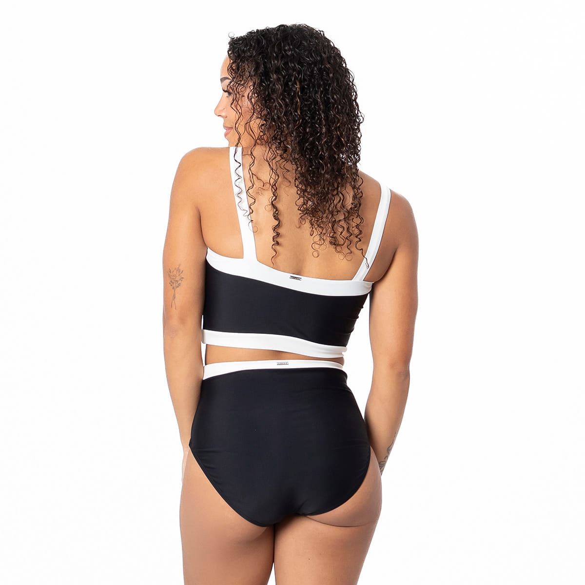 Woman wearing a black and white bikini on a white background
