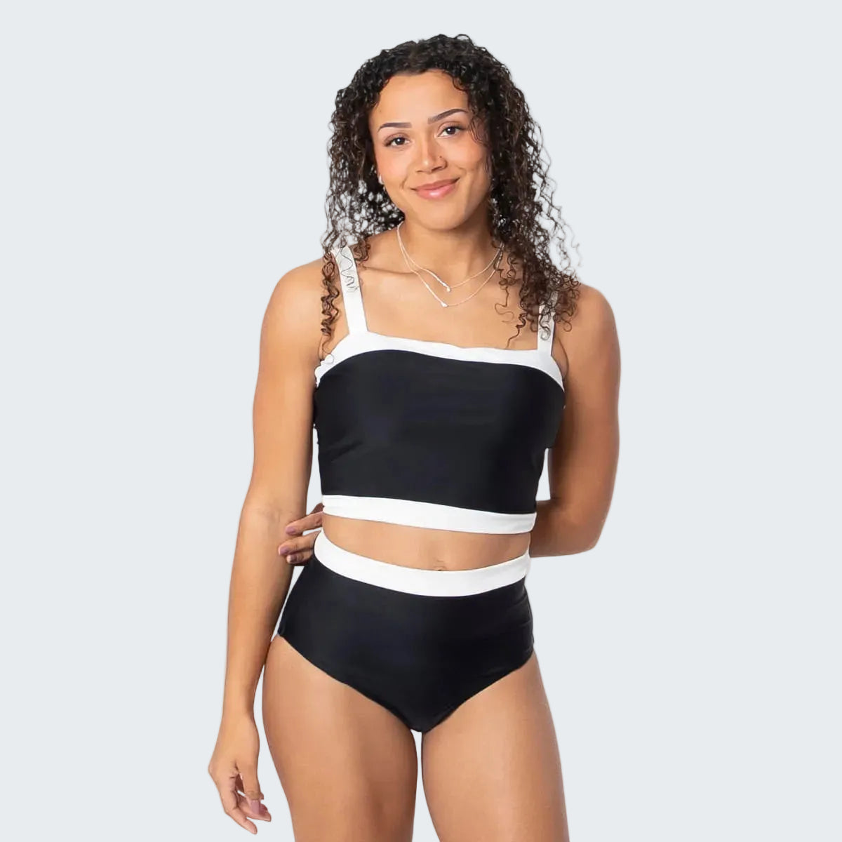 Woman wearing a black and white bikini on a white background