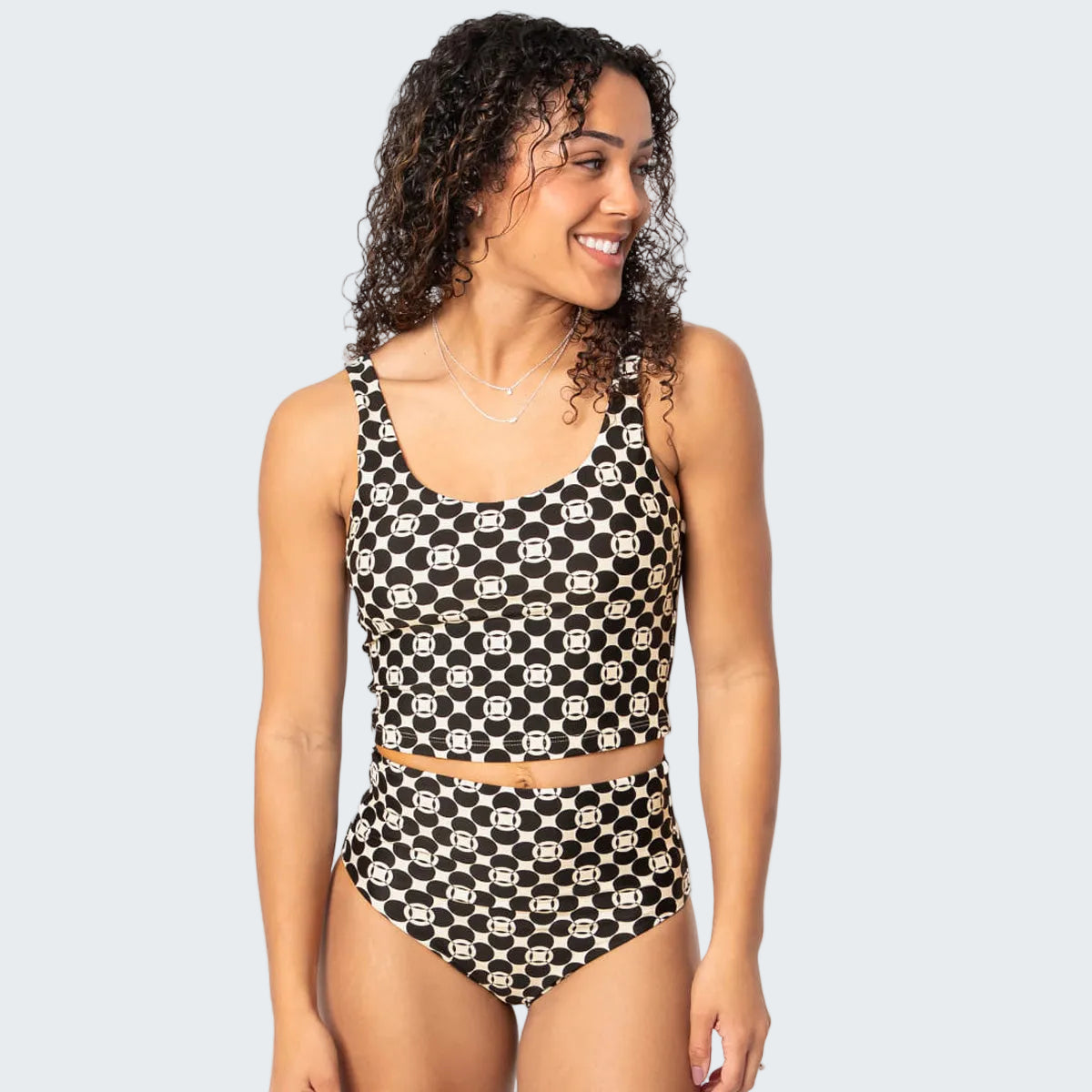 Woman wearing a black and white patterned swimsuit on a white background