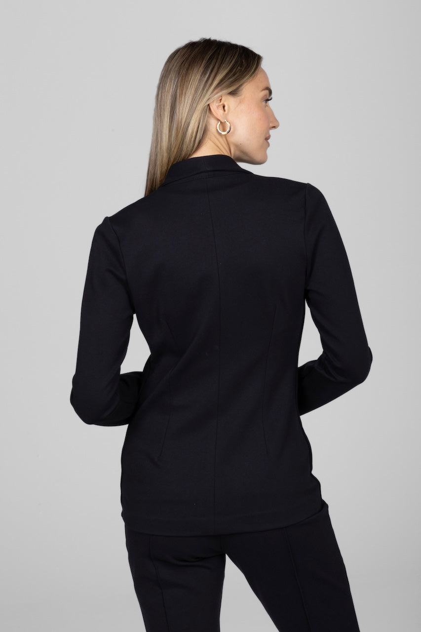 Woman wearing a black blazer against a gray background