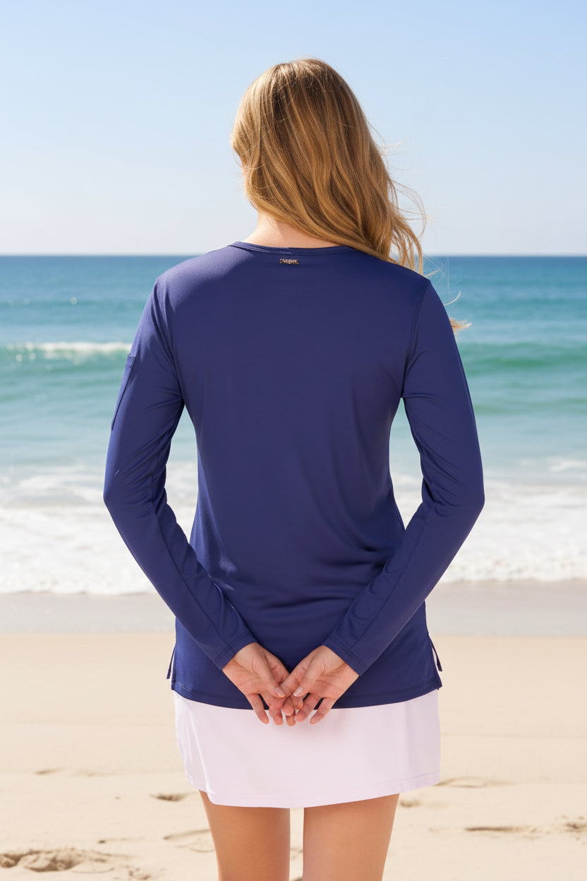Woman wearing a blue long-sleeve top and white skirt on a white background