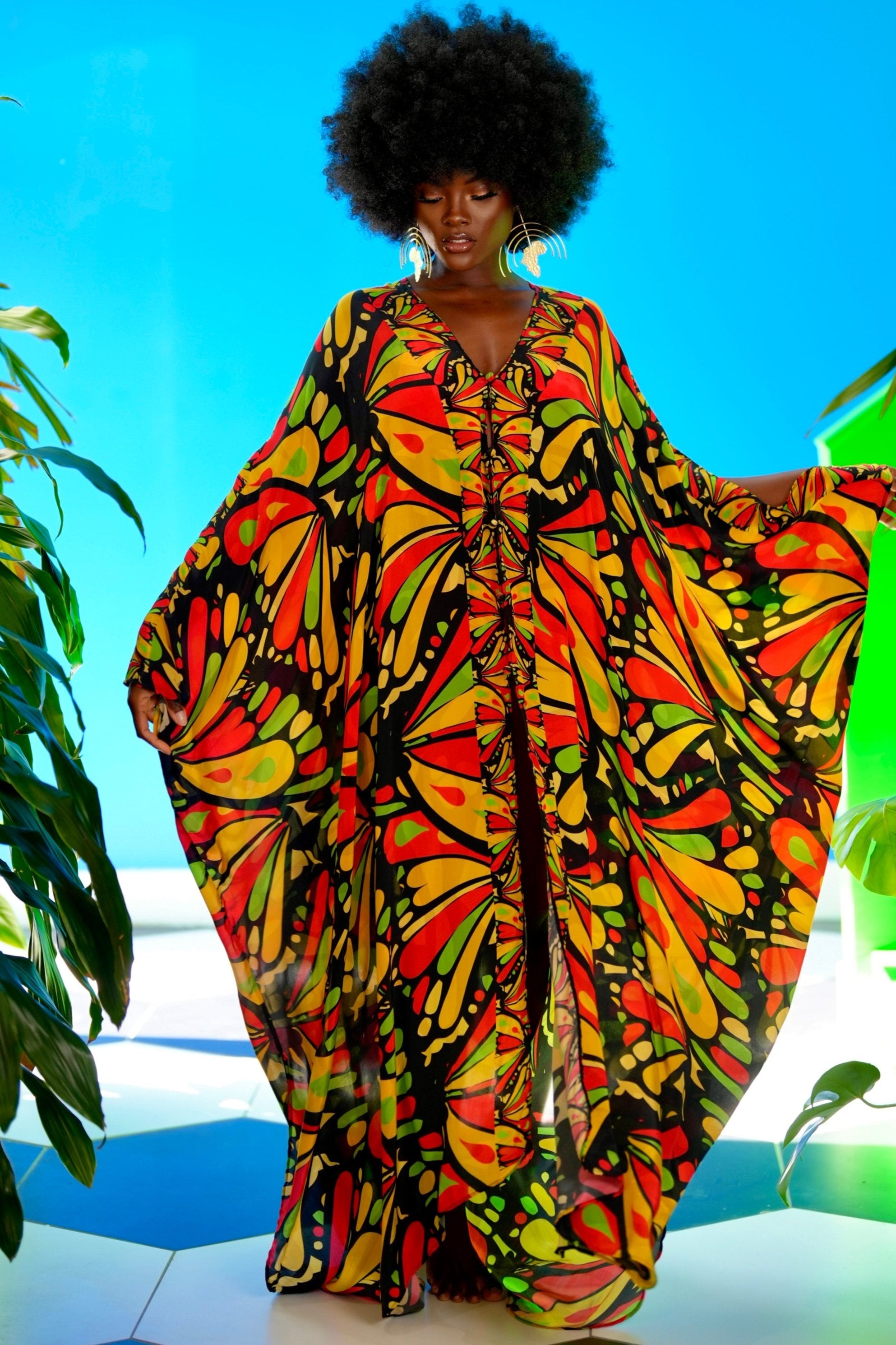Person wearing a colorful patterned dress with a bright blue sky background