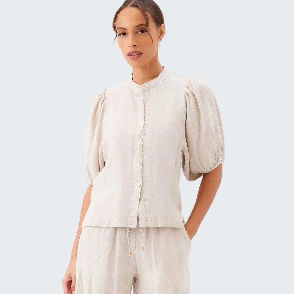 Woman wearing a beige blouse and pants on a white background