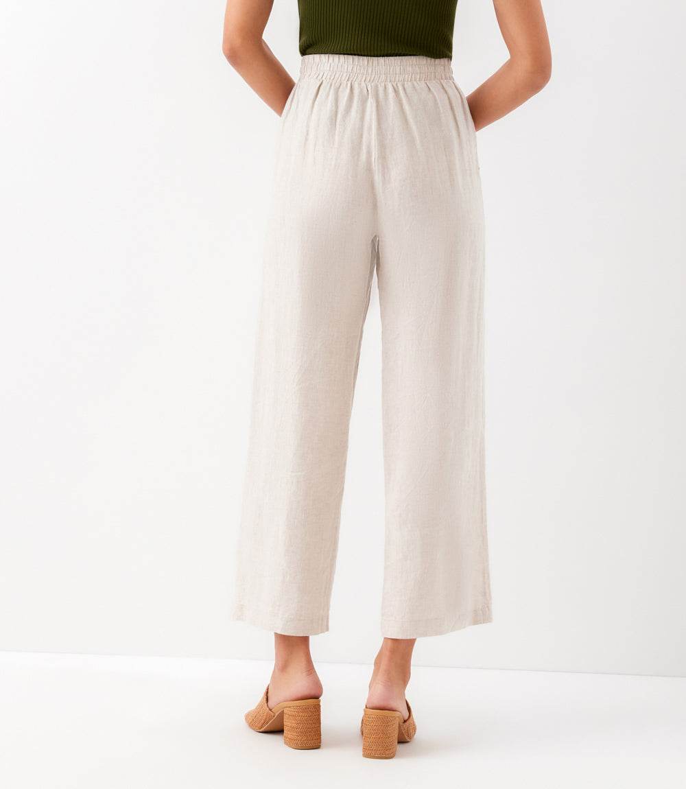 Person wearing white wide-leg pants on a white background