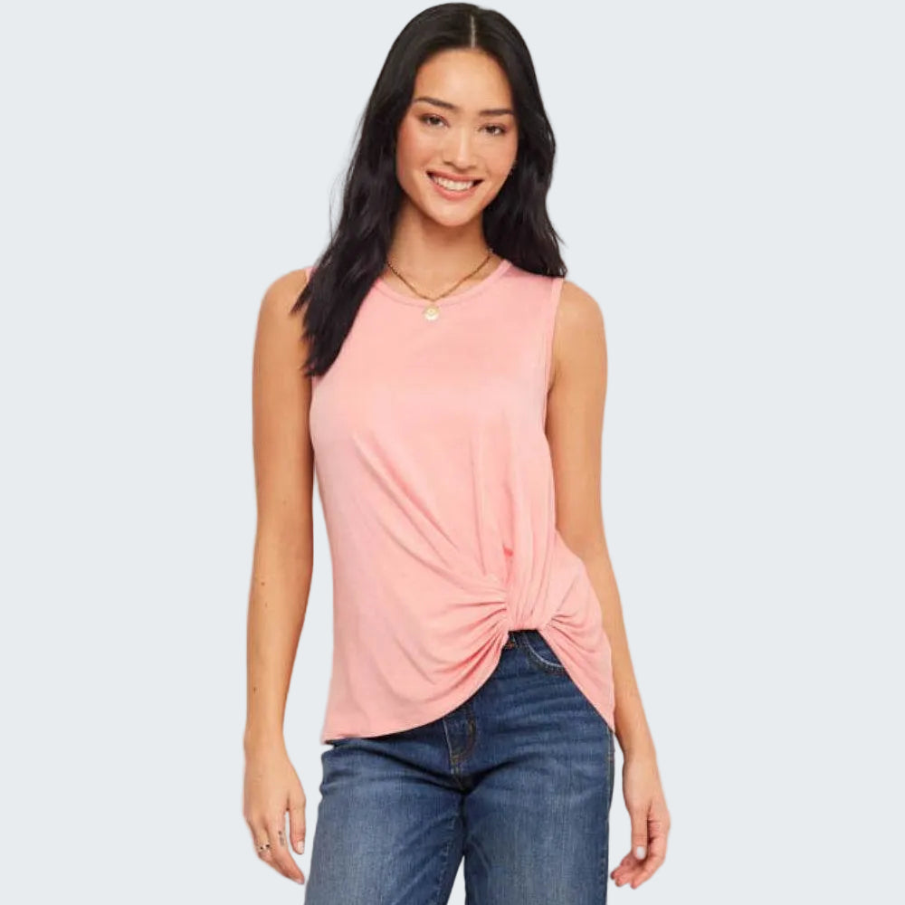 Woman wearing a pink sleeveless top with a knot detail and blue jeans on a white background