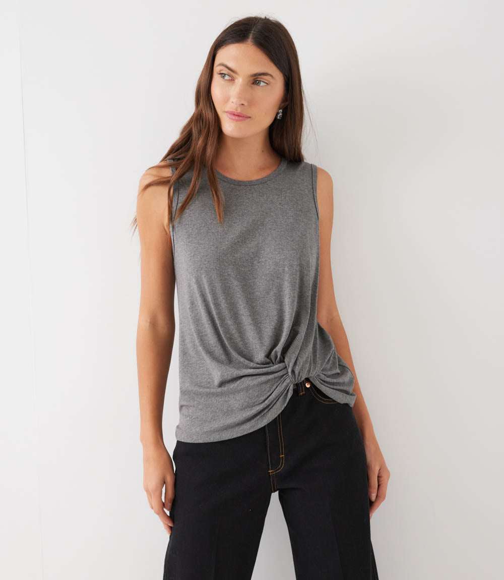 Woman wearing a gray sleeveless top with a knot detail on a white background