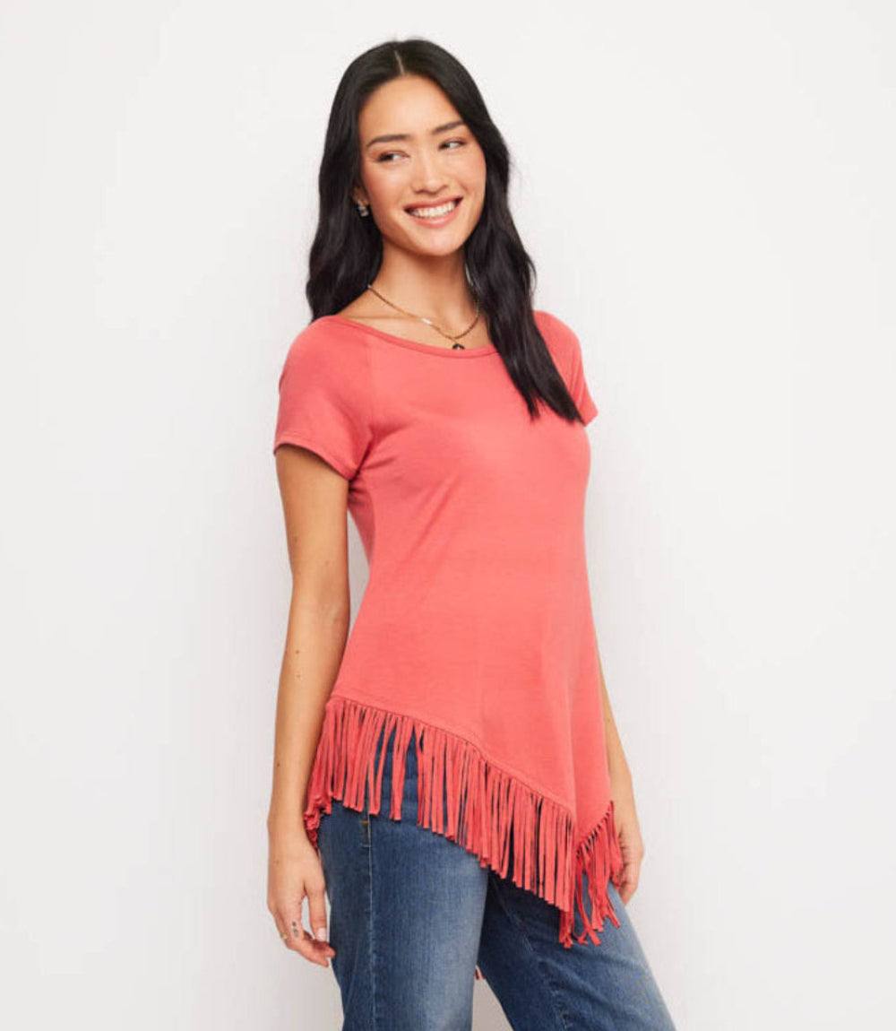 Woman wearing a coral tunic with fringe details on a white background