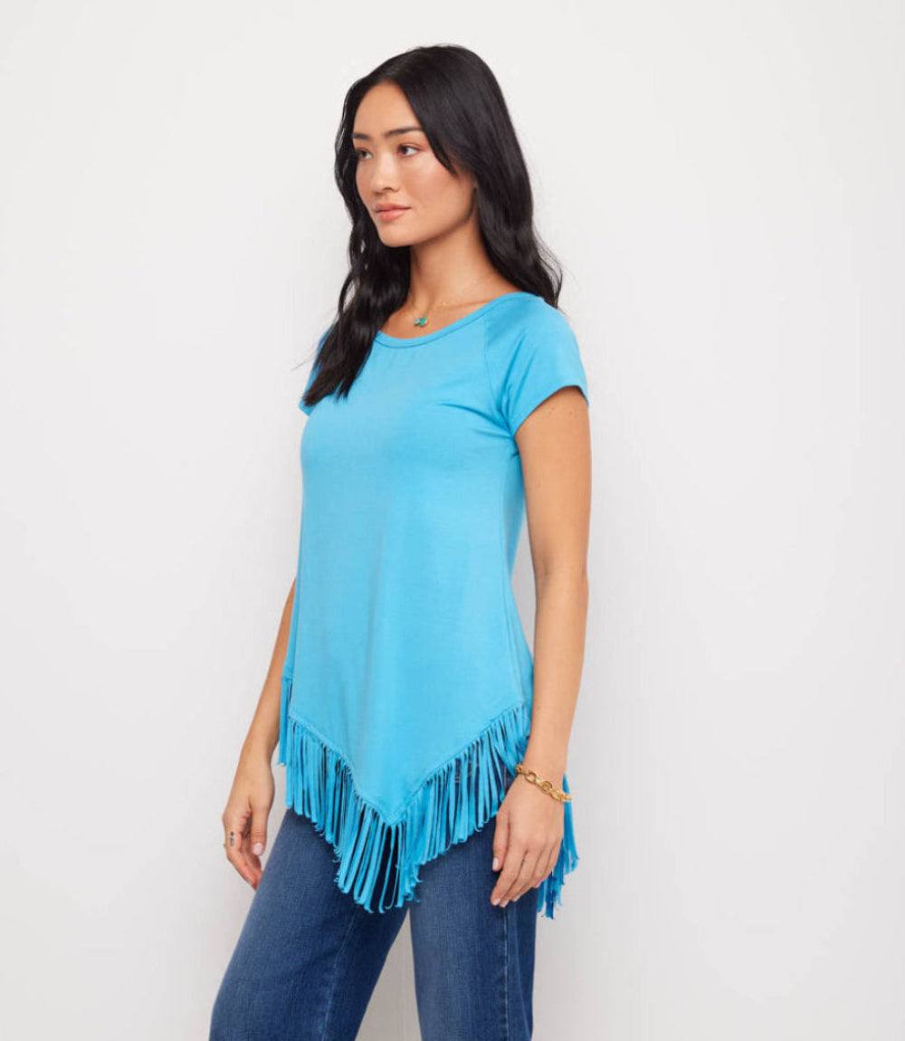Woman wearing a blue fringe top against a white background