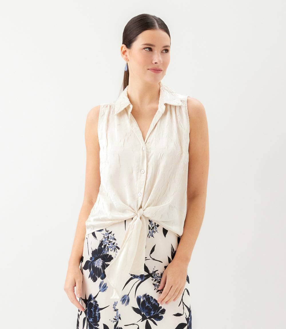 Woman wearing a sleeveless top with a floral skirt on a white background