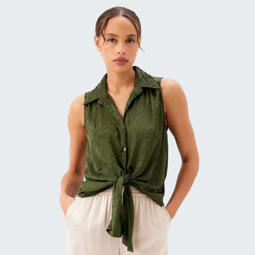 Woman wearing a green sleeveless top with a knot detail on a white background