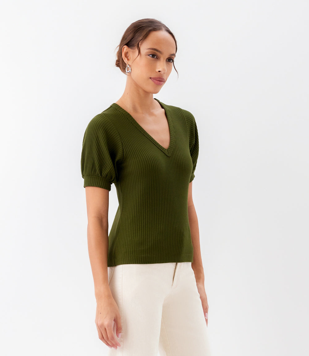 Woman wearing a green ribbed sweater with short sleeves on a white background
