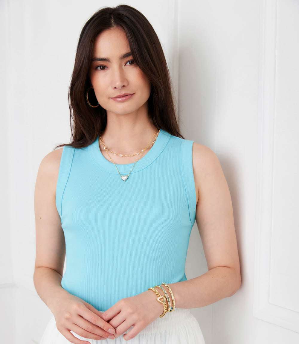 Woman wearing a light blue sleeveless top against a white background