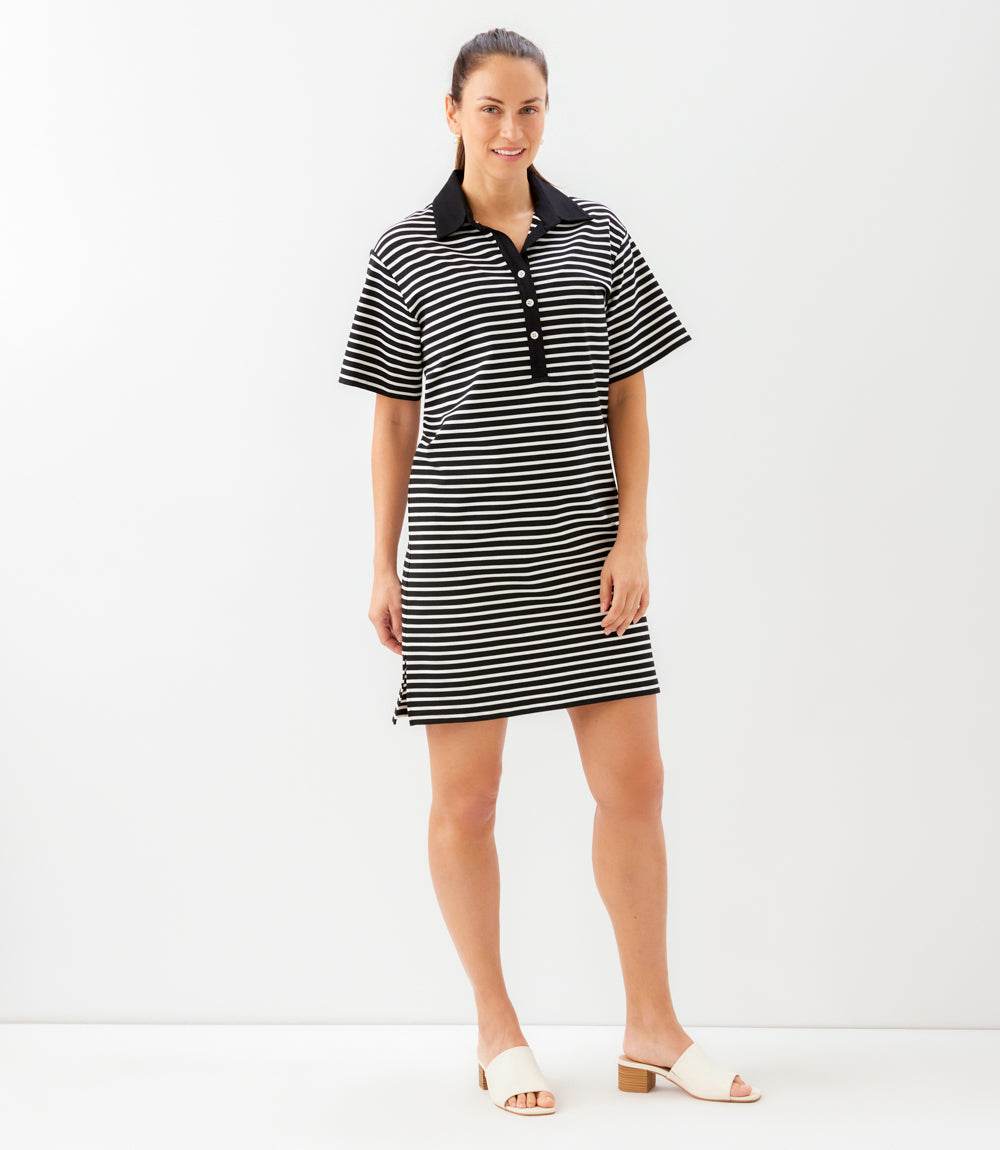 Woman wearing a black and white striped dress with a collar on a white background