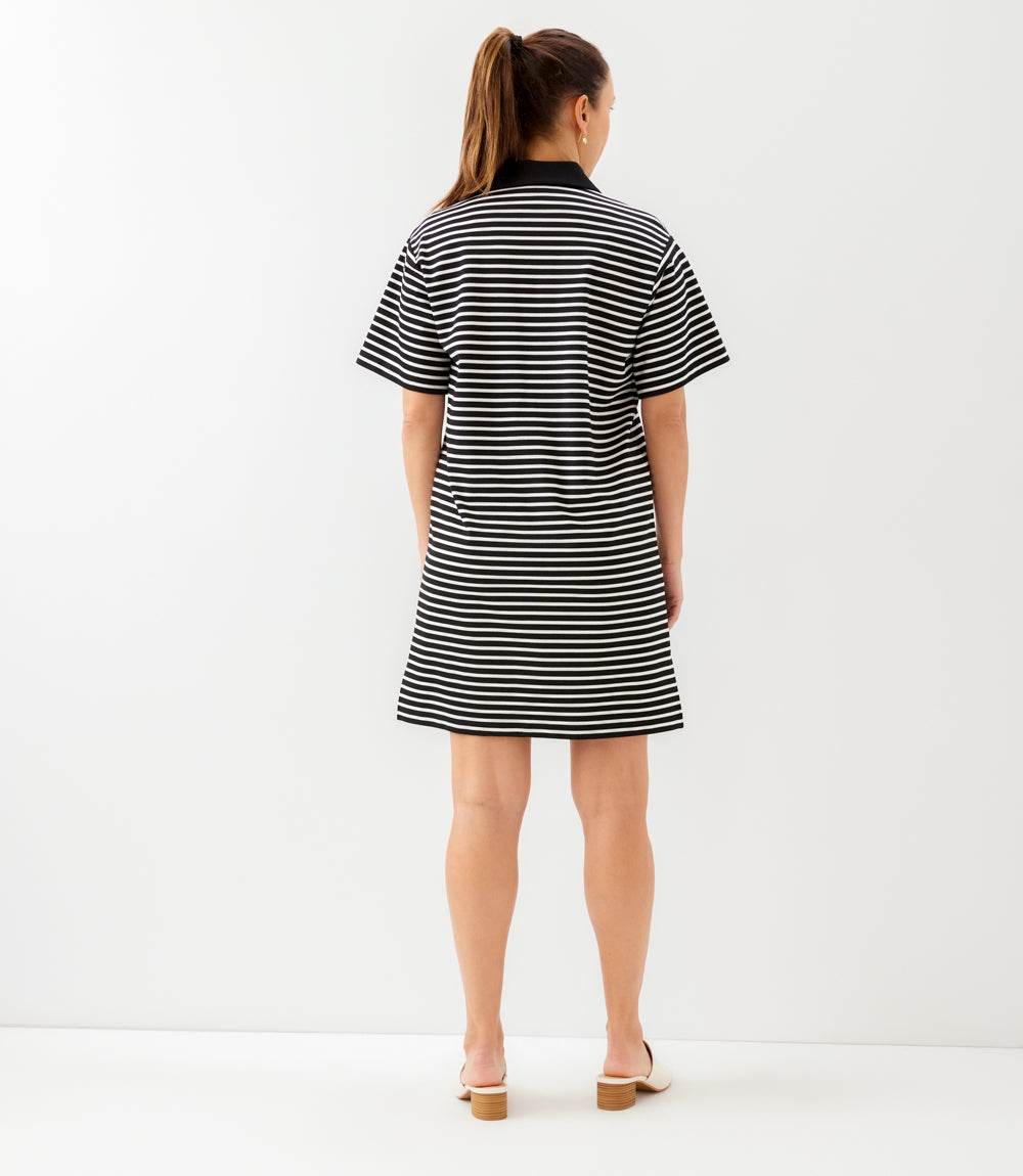 Woman wearing a black and white striped dress on a white background