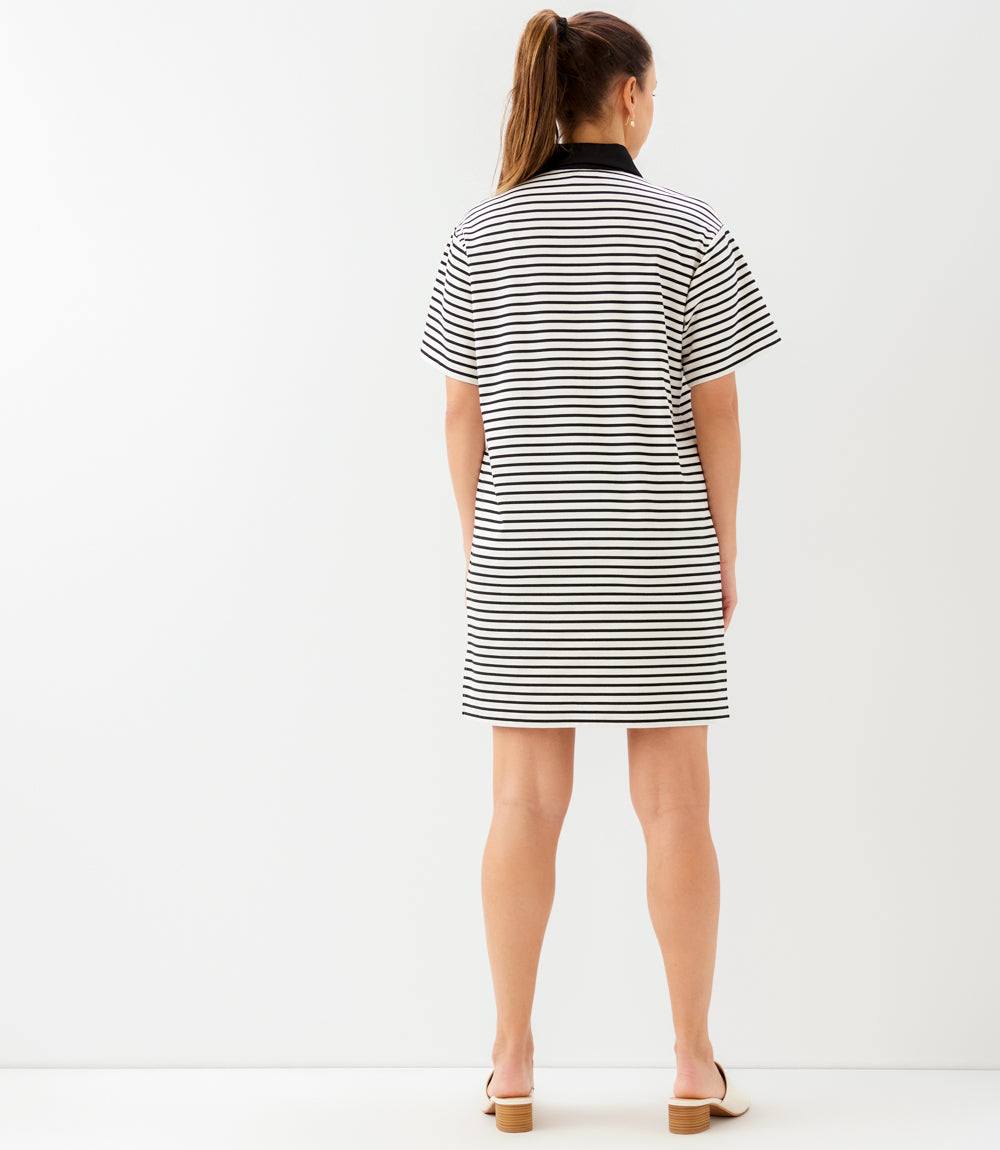 Woman wearing a black and white striped dress on a white background