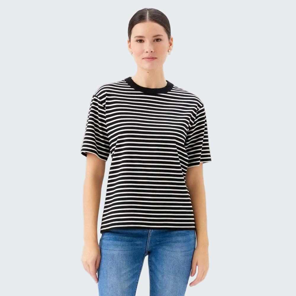 Person wearing a black and white striped t-shirt and blue jeans on a white background
