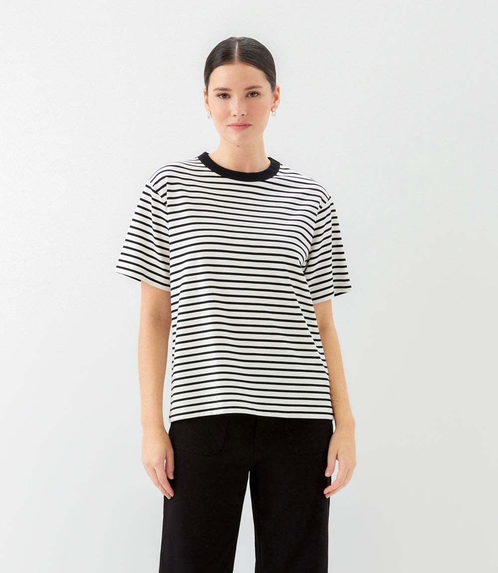 Person wearing a black and white striped t-shirt on a plain background