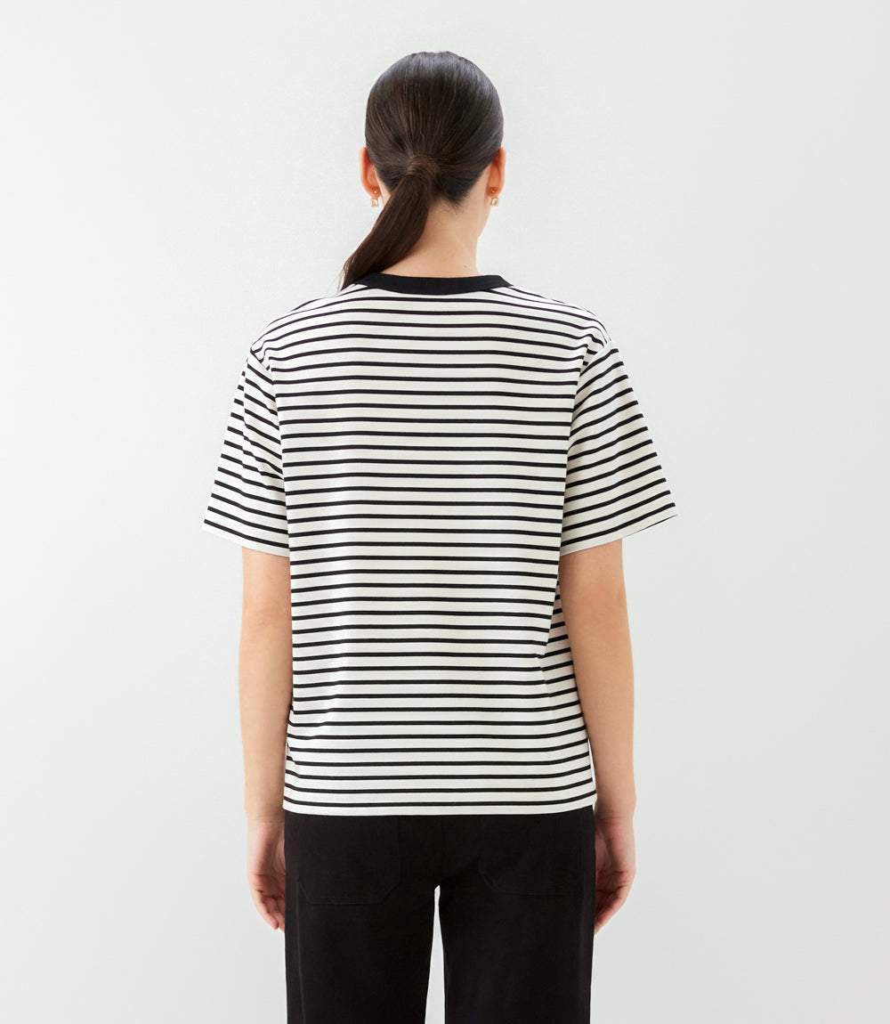 Person wearing a black and white striped t-shirt on a plain background