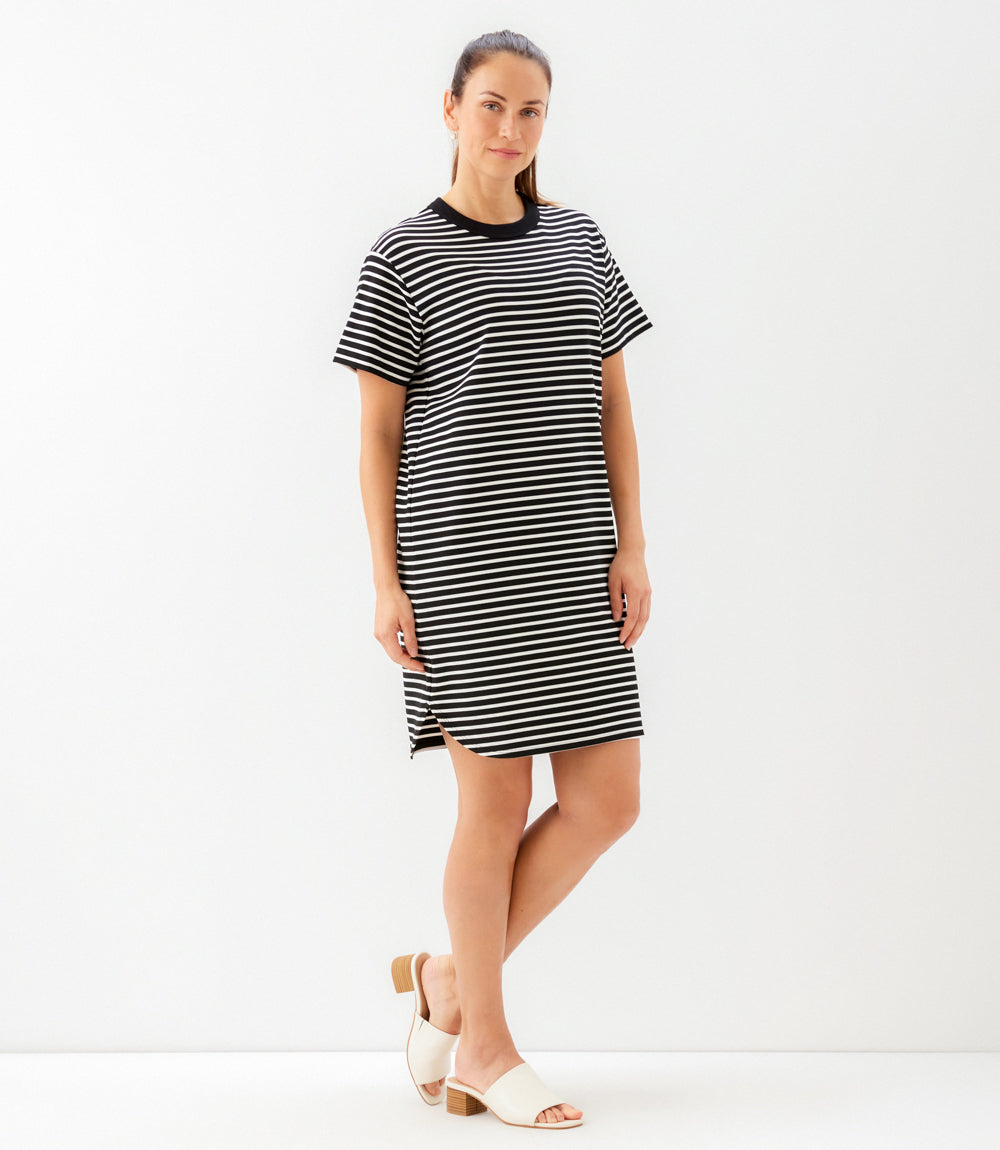 Woman wearing a black and white striped dress on a white background