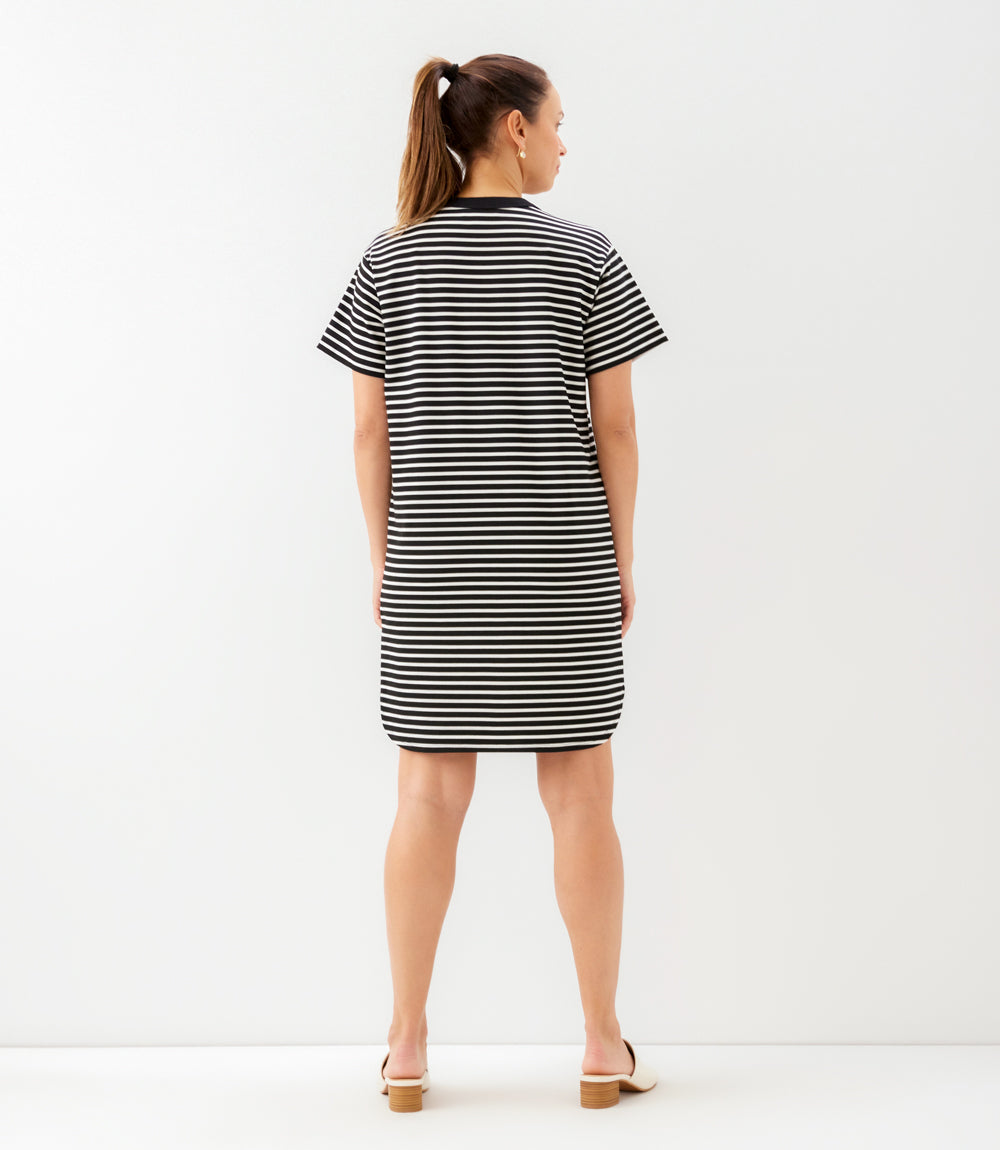 Woman wearing a black and white striped dress on a white background