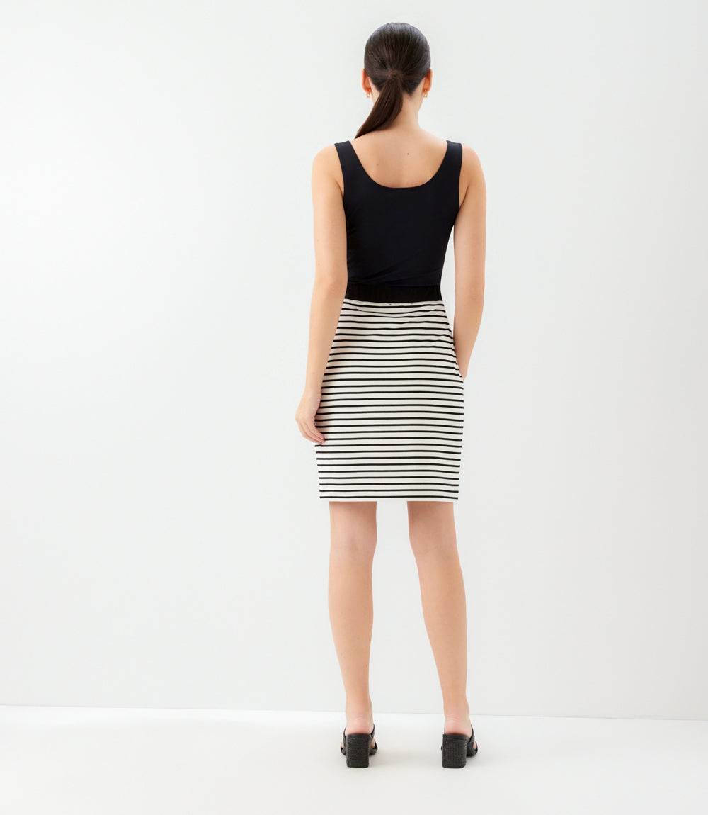 Woman wearing a black tank top and striped skirt on a white background