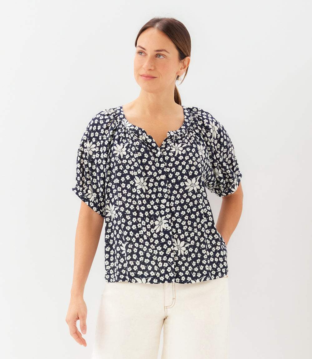Woman wearing a black floral blouse against a white background