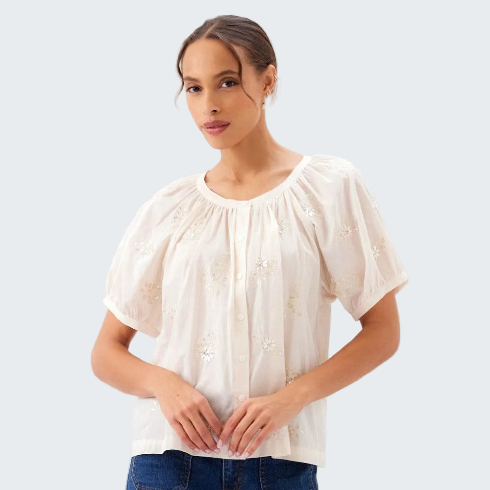 Woman wearing a white blouse with short sleeves and blue jeans on a white background