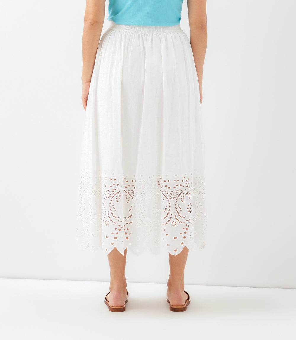White pants with cut-out patterns worn by a person on a white background