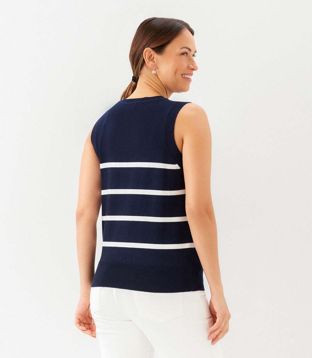 Woman wearing a navy and white striped sleeveless top against a white background