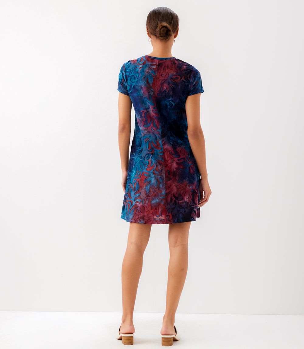 Woman wearing a tie-dye dress on a white background