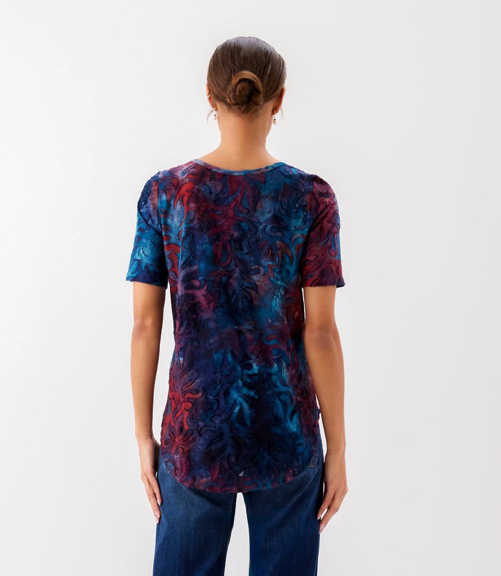 Person wearing a tie-dye t-shirt with a white background