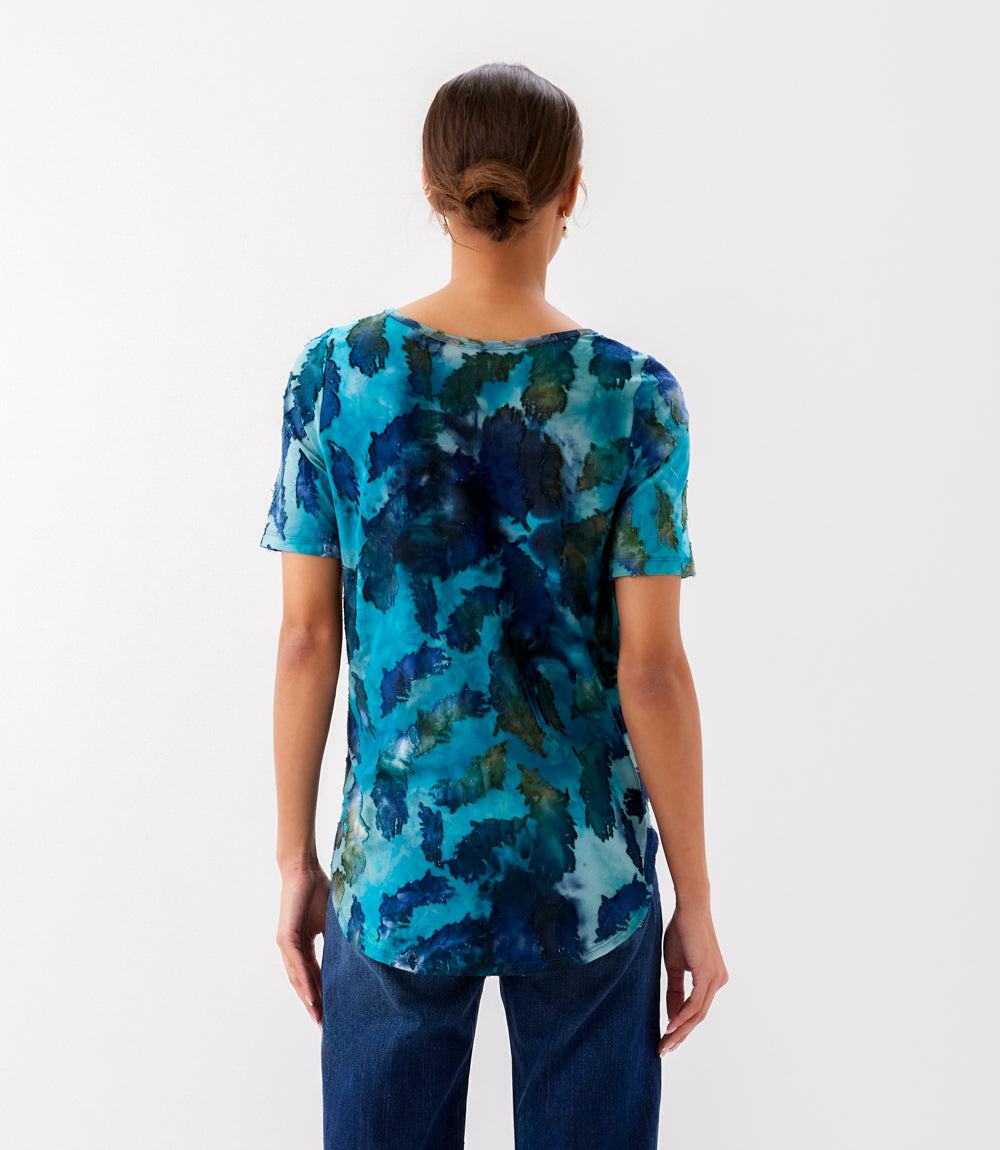 Woman wearing a blue floral patterned shirt on a white background