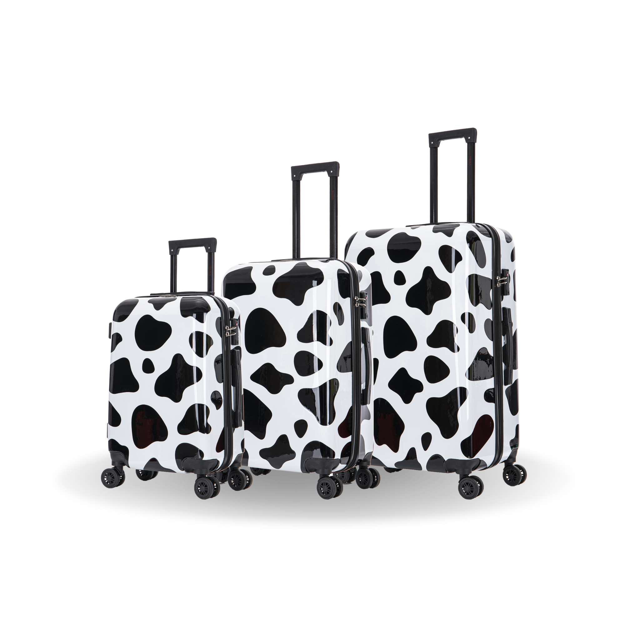 Set of three cow print suitcases on a white background