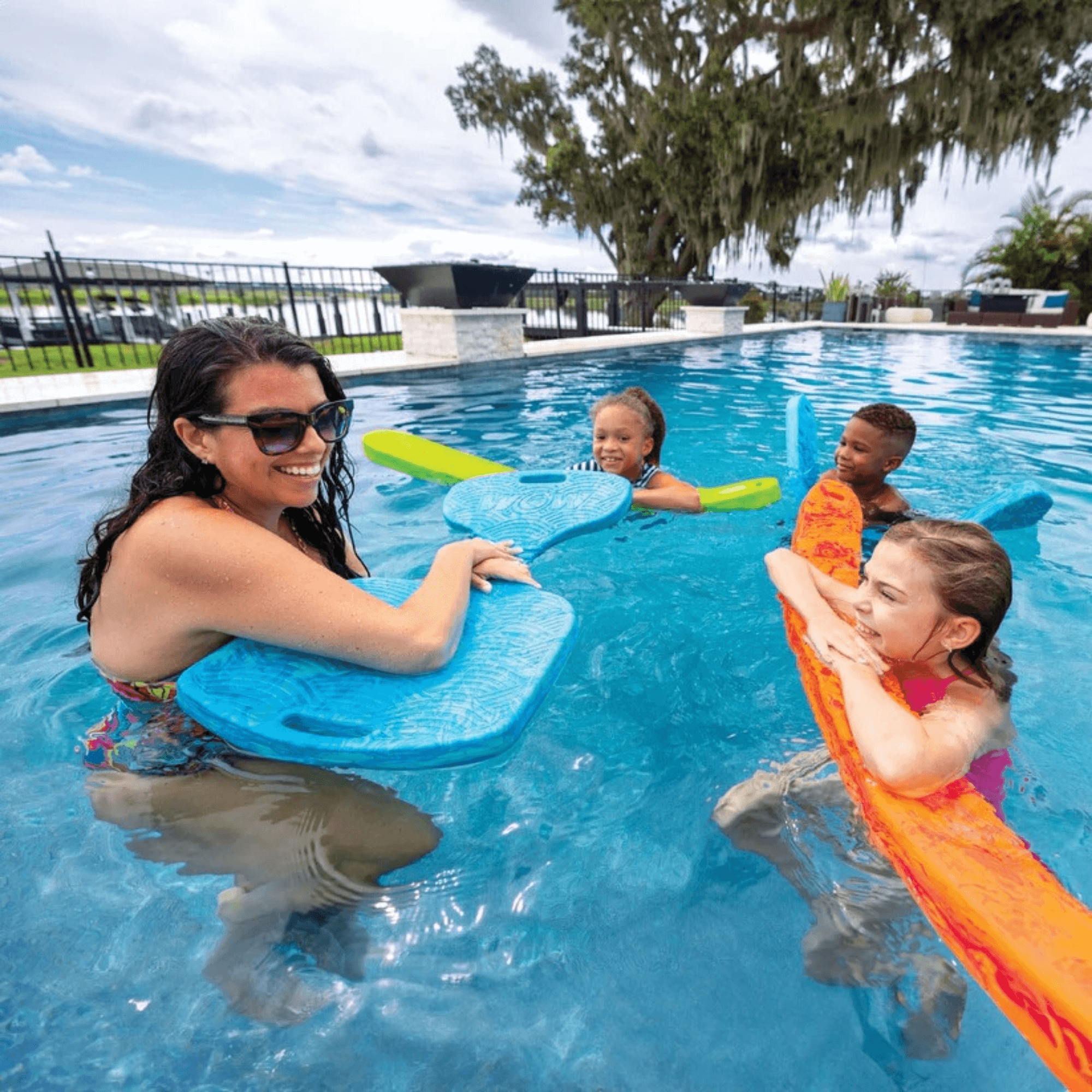 Woman and children in a pool with floaties on a sunny day