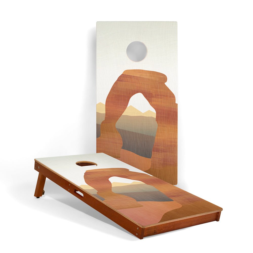 Cornhole board with desert arch design on a white background